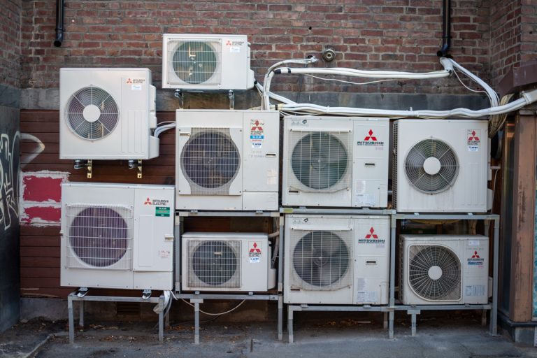 Mitsubishi Electric air conditioners on a building wall., Mitsubishi P Series Vs. M Series: Which HVAC System To Choose?