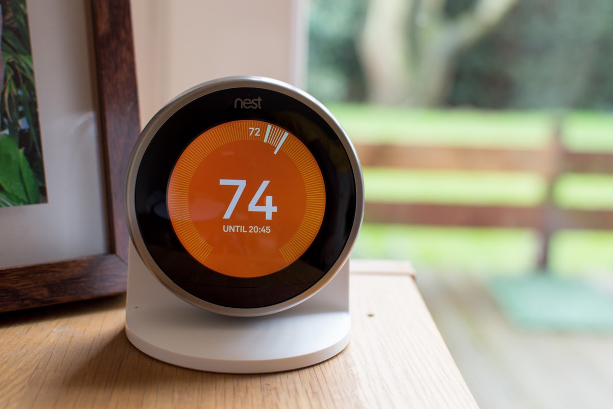 Nest Smart thermostat showing orange display as heating on indicator