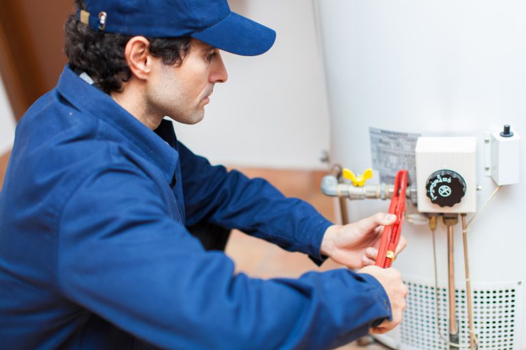 Plumber fixing an hot-water heater, How Much Does It Cost To Repair A Water Heater?