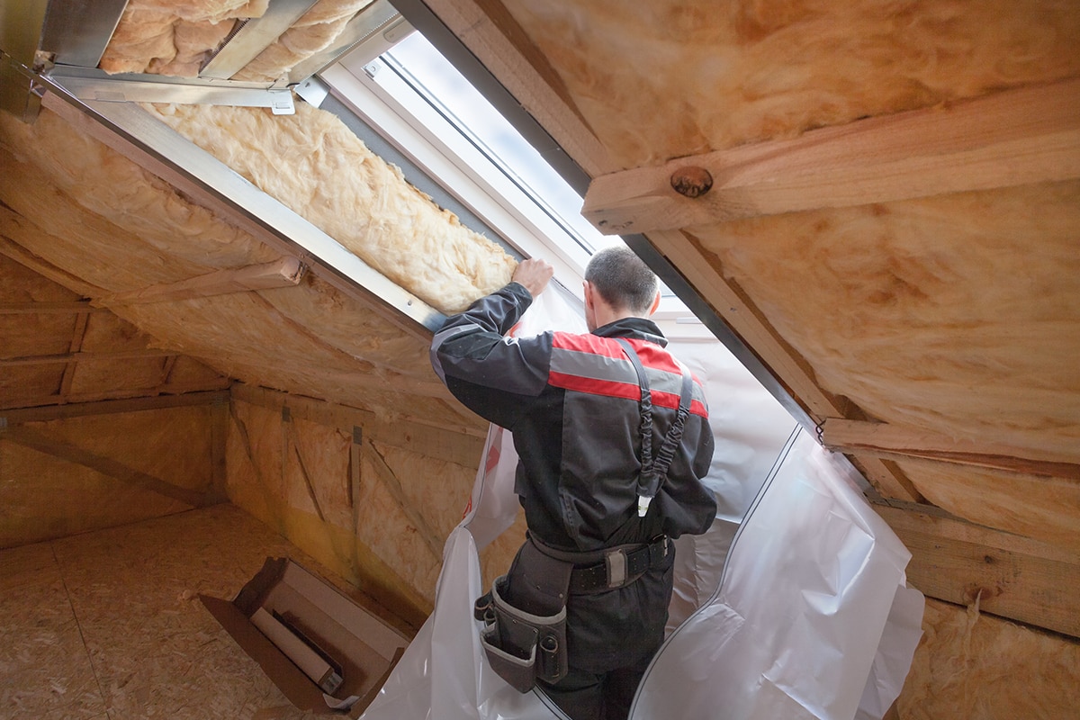 Worker installing vapor barrier around the skylight opening