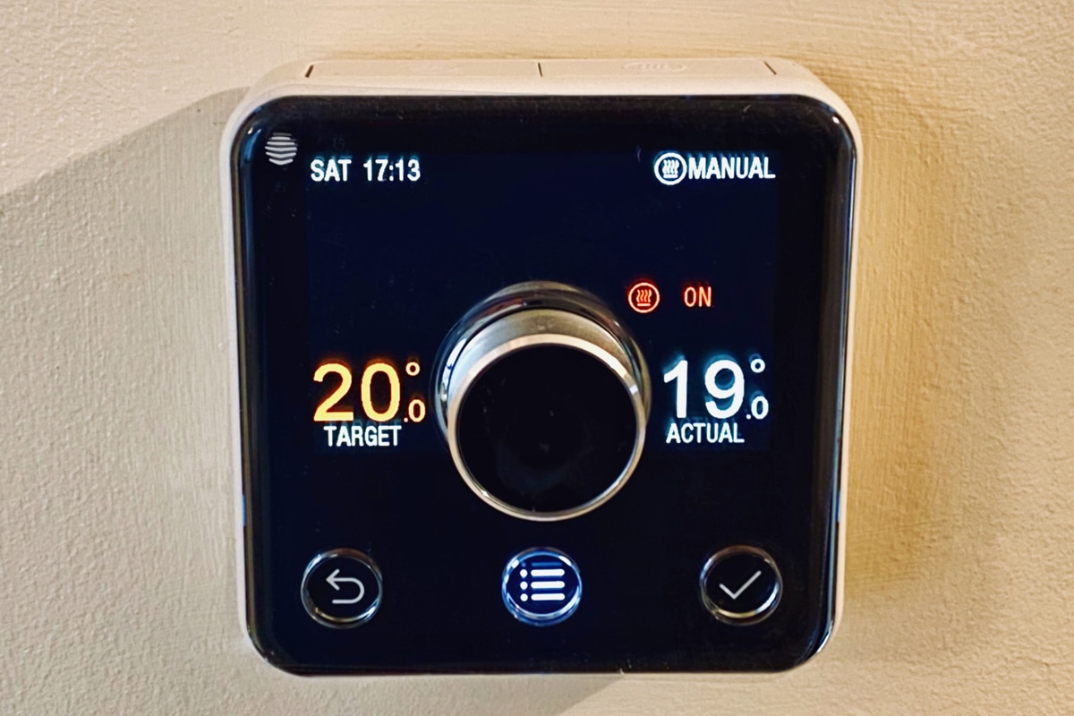 Close up of the control panel of a HIVE central heating control and thermostat on the wall