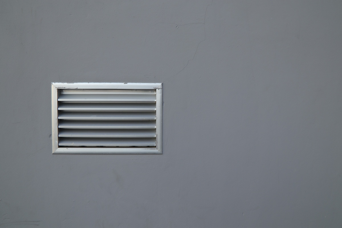 Metal air conditioning vent on the gray concrete wall