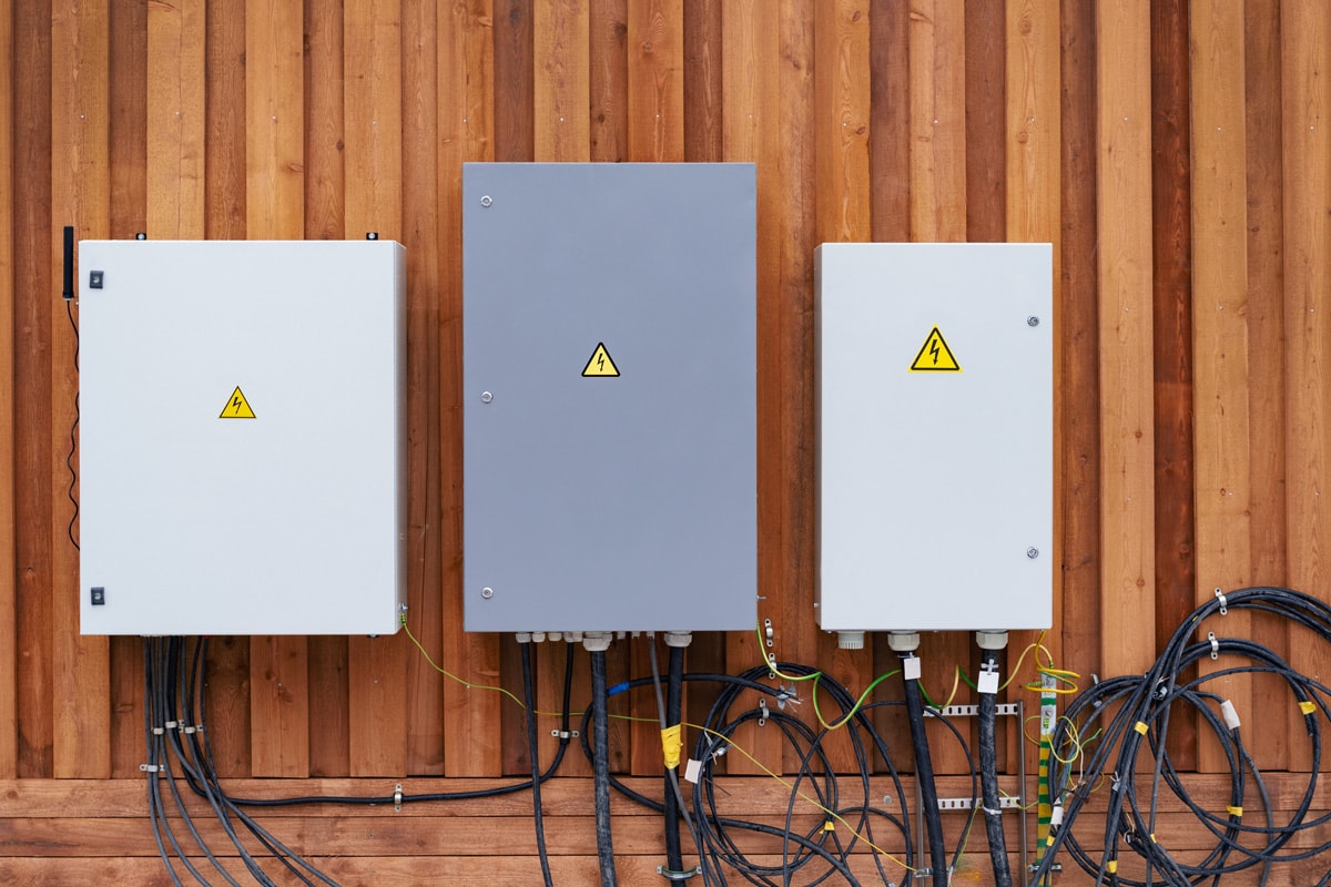 Three electrical panels mounted on a wooden wall