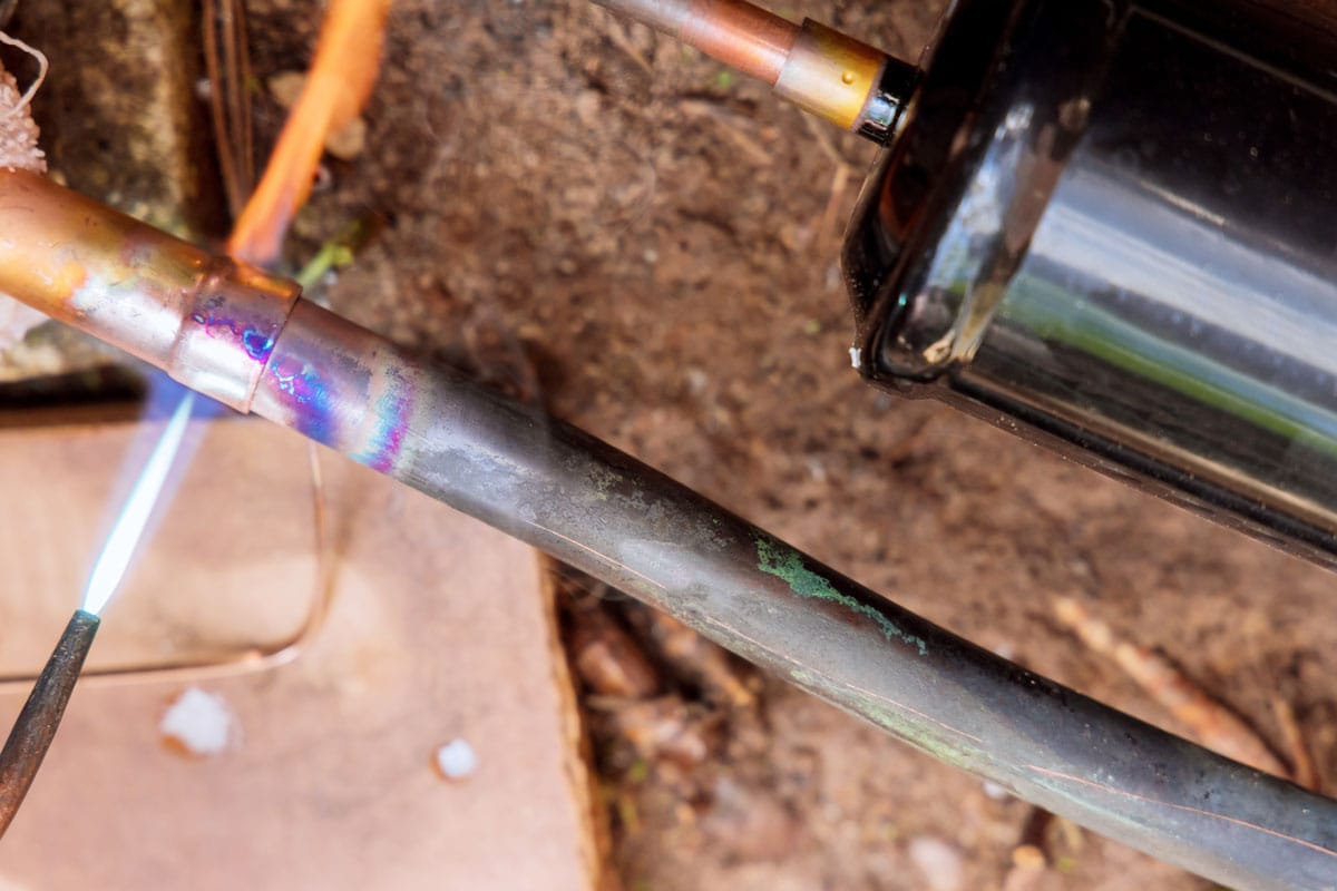 Using a blow torch to solder a plumbing pipe