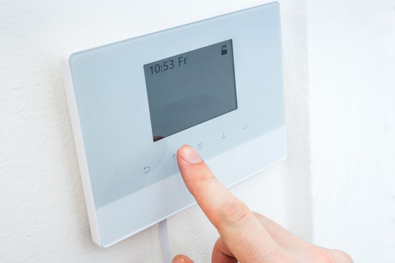 Woman adjusting the thermostat, Effortlessly Connect Your Sinope Thermostat with This Step-by-Step Guide