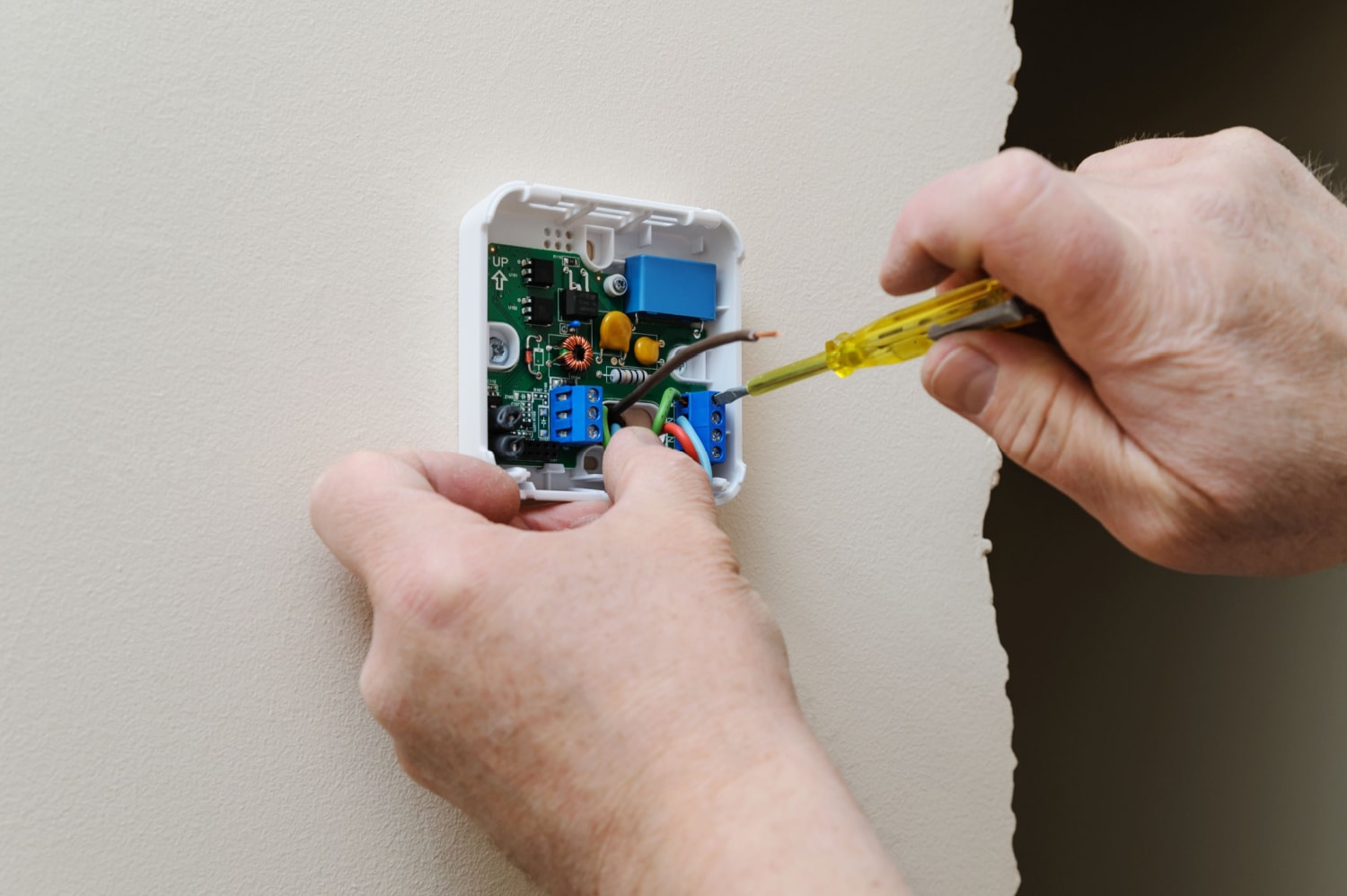 Installing or unscrewing a thermostat mounting plate on the wall