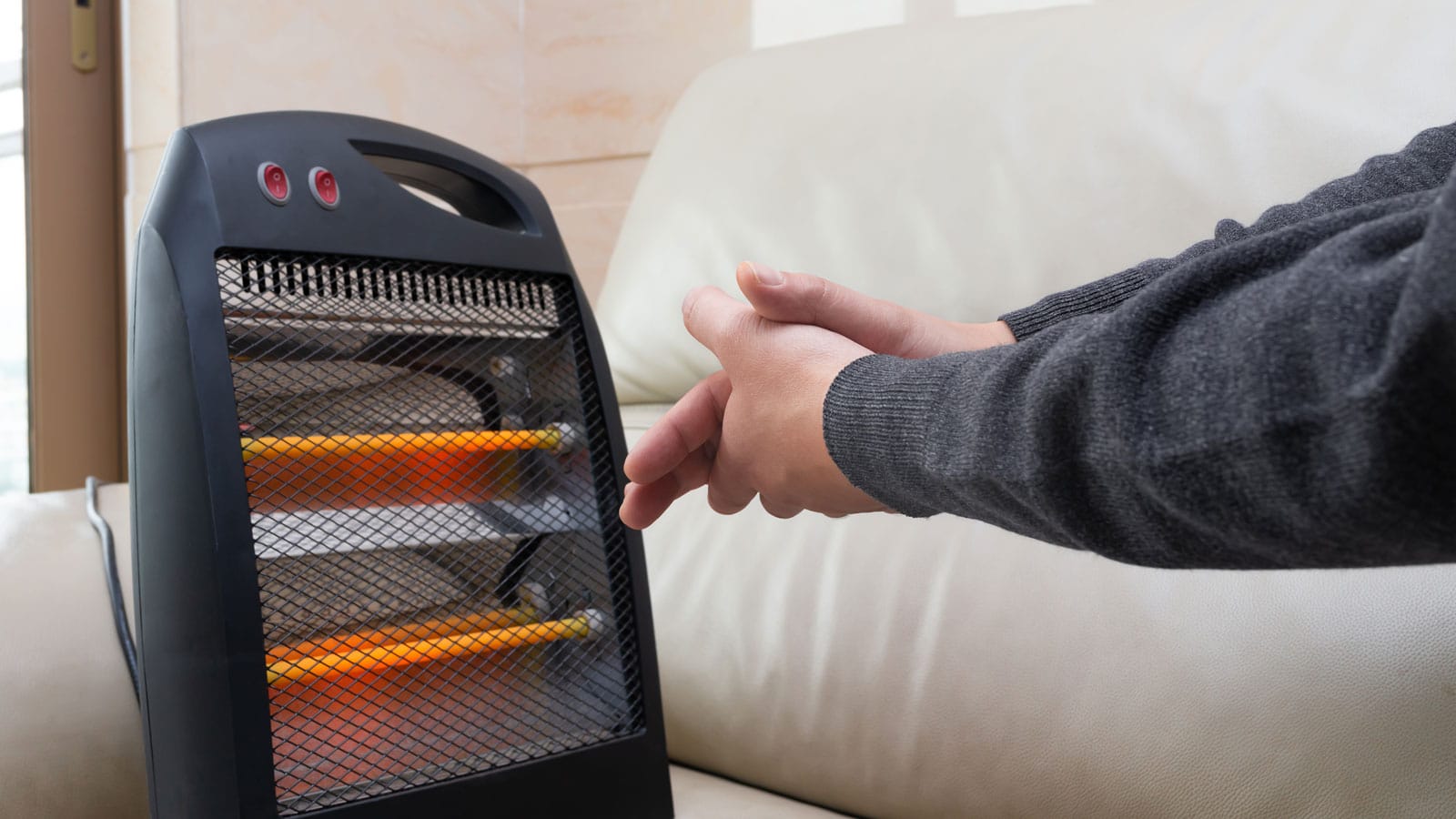Man putting his hands close to the heater