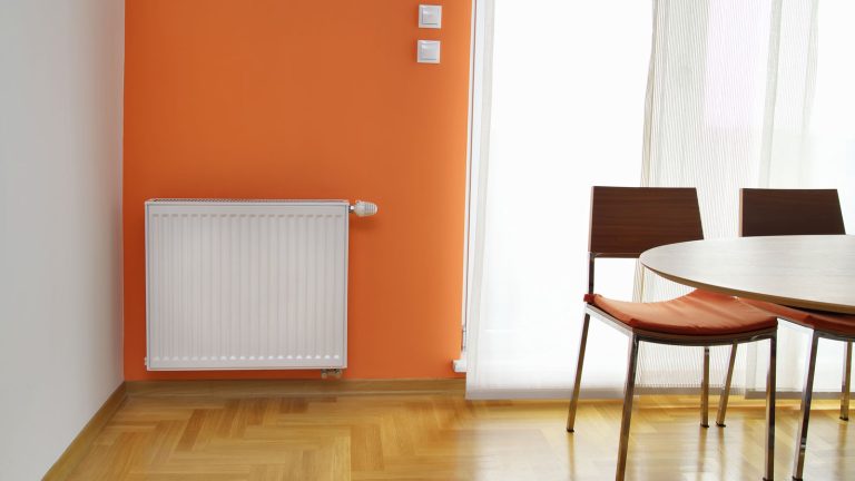 An orange wall with a mounted wall heater, How To Turn Off Cadet Wall Heater [+Troubleshooting] - 1600x900