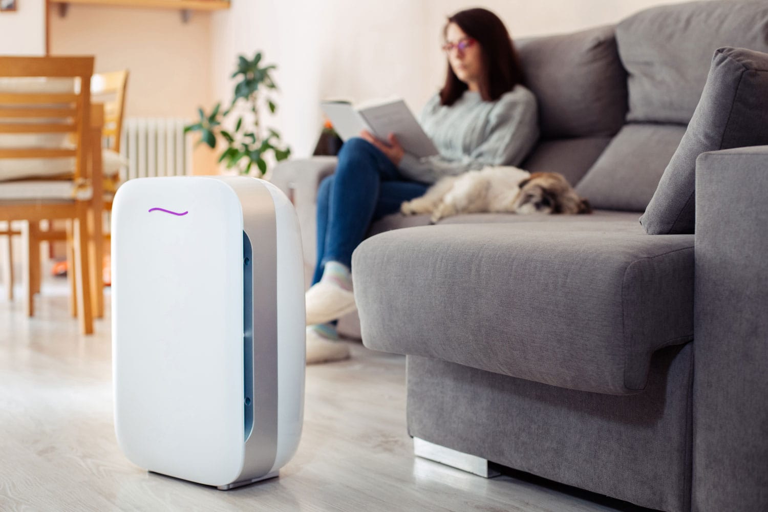 Woman relaxing in the living room with the air purifier turned on